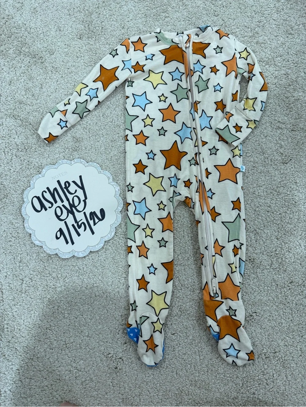 Posh Peanut Cream Footed One-Piece Pajamas with Orange, Blue & Green Stars